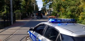 Na zdjęciu widać radiowóz a w oddali pojazd patrolu saperskiego