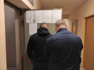 Na zdjęciu widoczny jest zatrzymany 35-latek wraz z umundurowanym policjantem