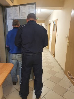 policjant z zatrzymanym mężczyzną